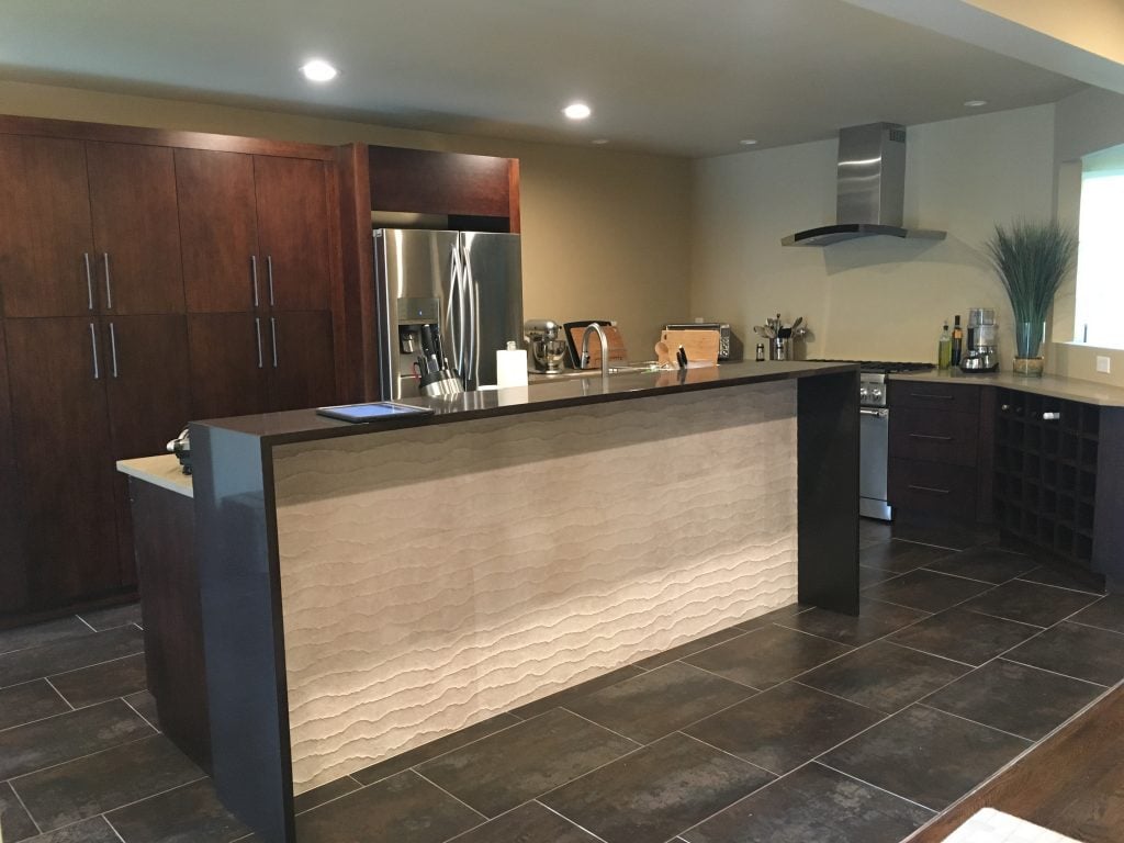 Modern and Open Kitchen with Tiled Island Front, Free-standing Hood, Stainless Steel Appliances, Wine Cabinetry