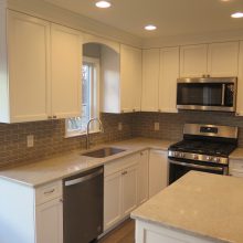 Kitchen Transformation - All new white cabinetry, quartz countertops, beveled backsplash, new window over sink