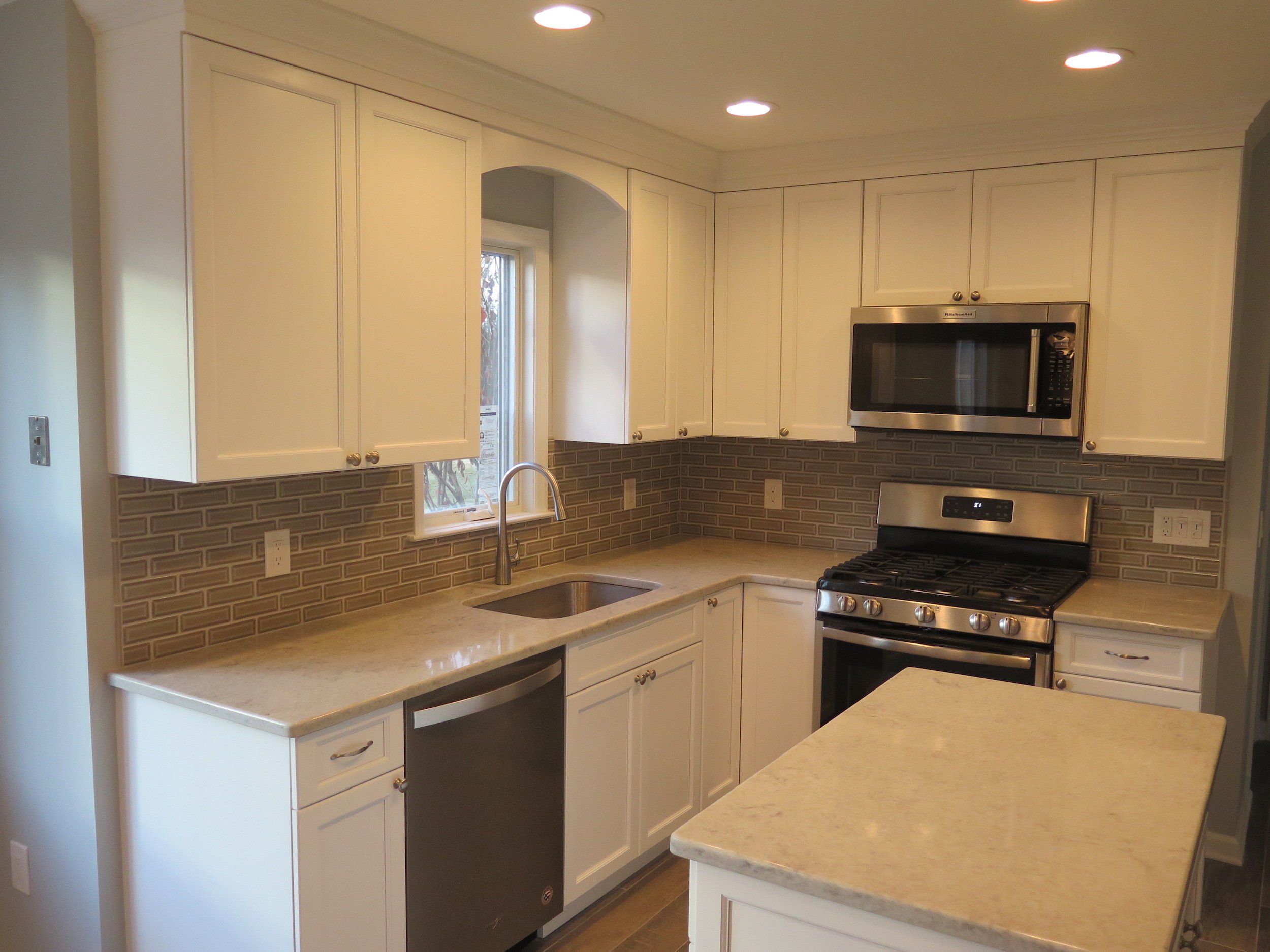 Kitchen Transformation - All new white cabinetry, quartz countertops, beveled backsplash, new window over sink