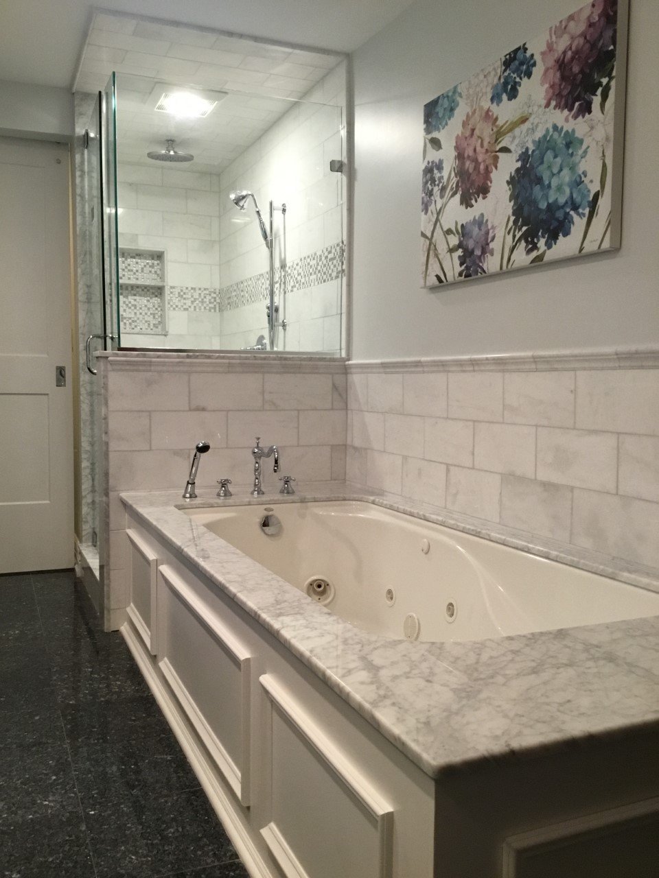 A modern bathroom with a blue cabinet, tile and stone back splash, and  marble tiling the floor / shower. Stock Photo